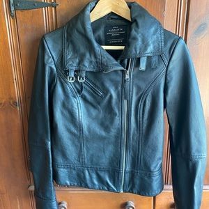 AllSaints black leather jacket. Fully lined, front zip, buckle and snap details.